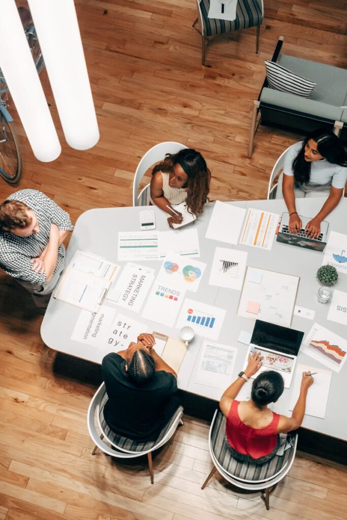 High-angle view of diverse team collaborating on a business project in a modern office.